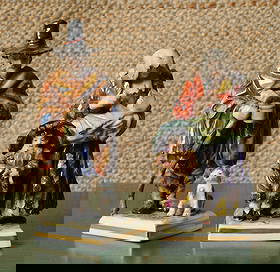 Volkstedt, Dresden & Capodimonte Beggar Figures: Male figure with begging cup, staff, and a dog at his feet, with underglaze blue Volkstedt, Dresden mark to base, Female figure holds a baby in her arms, carries an infant on her back, and has a small