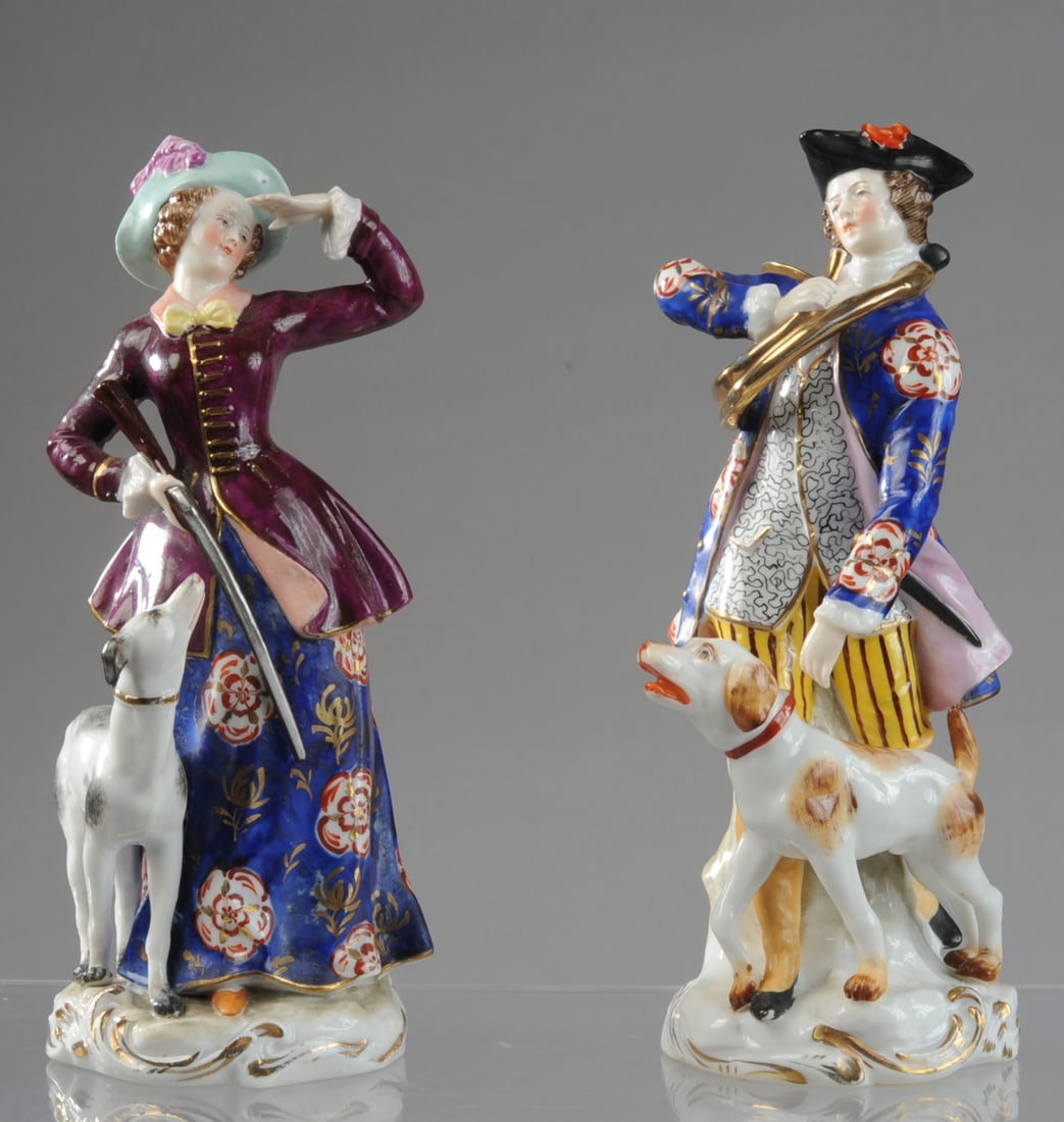 Pair of Samson Porcelain Hunting Figures: A matched pair of 20th century Samson porcelain figures of a huntsman and companion, modeled after Chelsea Gold Anchor period examples, each accompanied by a hound. The gentleman in tricorne hat and f