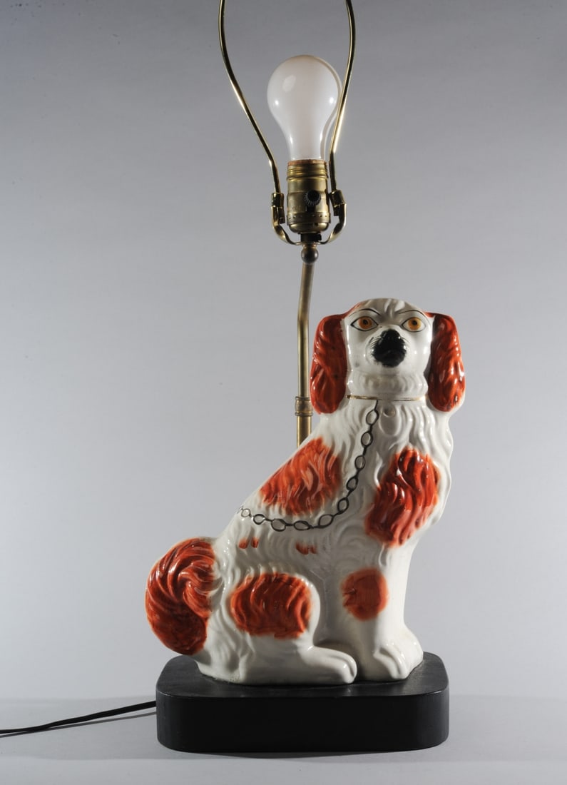 Staffordshire Spaniel Lamp: Red and white spotted Staffordshire style porcelain spaniel, made into a lamp in the mid 20th C. Total height to top of finial, approx. 25" H. Height to top of socket, approx. 16". Our primary recomme