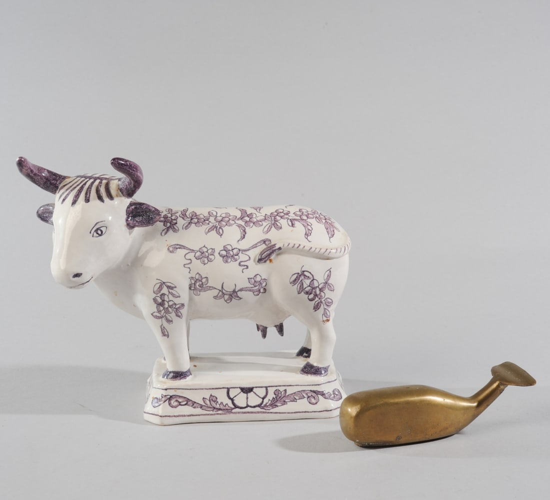 Italian Glazed Ceramic Cow Figure +: Marked ITALY on the underside. Hand painted floral decoration in purple on a white glaze, standing on an integral rectangular base. Likely mid 20th century Italian earthenware, exact maker unknown. No