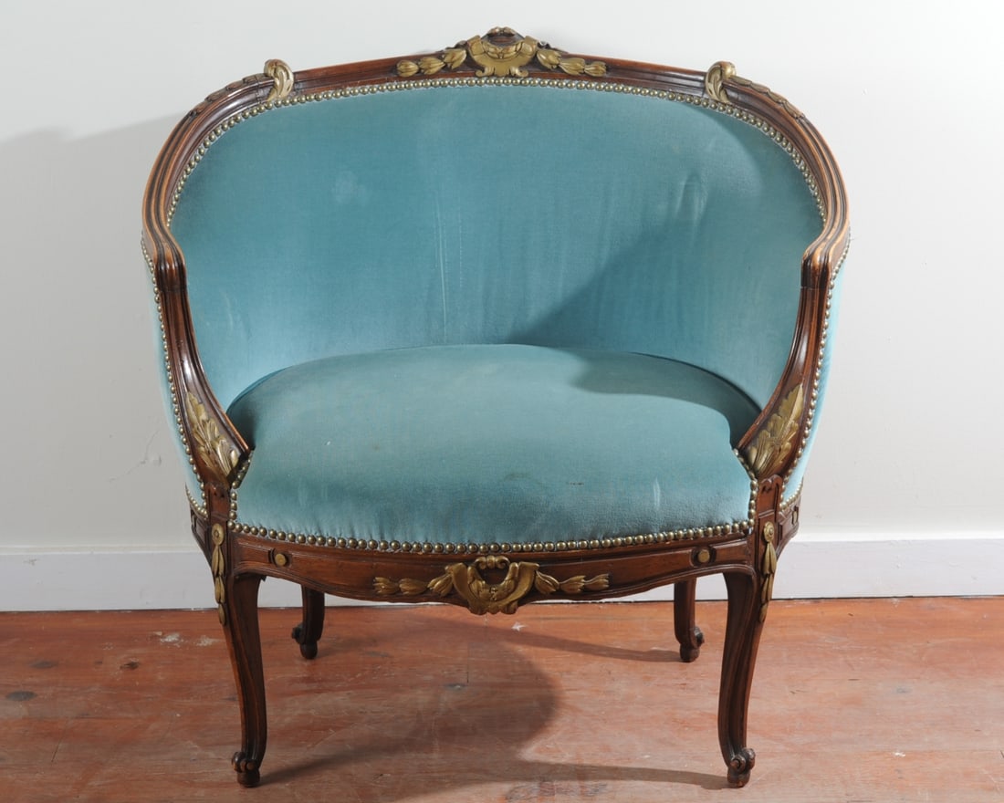 19th C. French Louis XVI Style Bergere Gondole: Parcel gilt late 19th C. Louis XVI style bergere with broad seat, continuous C-curve back. Crest carved with ribbon tied laurel wreath and sprays, apron with swagged laurel, arms with acanthus leaves,