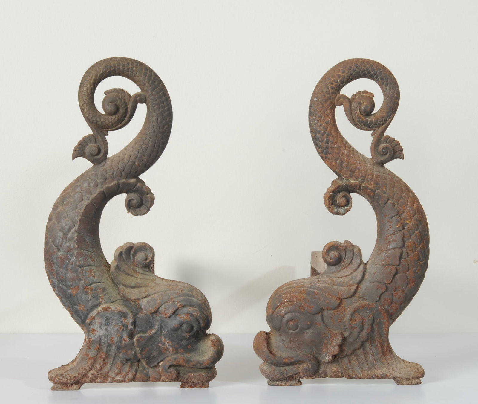 Pair Antique Dolphin Form Andirons: A fine pair of cast iron dolphin-form andirons, probably English, with scrolling foliate detail and forged iron supports. H: approx. 14". W: approx. 7". D: approx. 12 1/2". Our primary recommendation