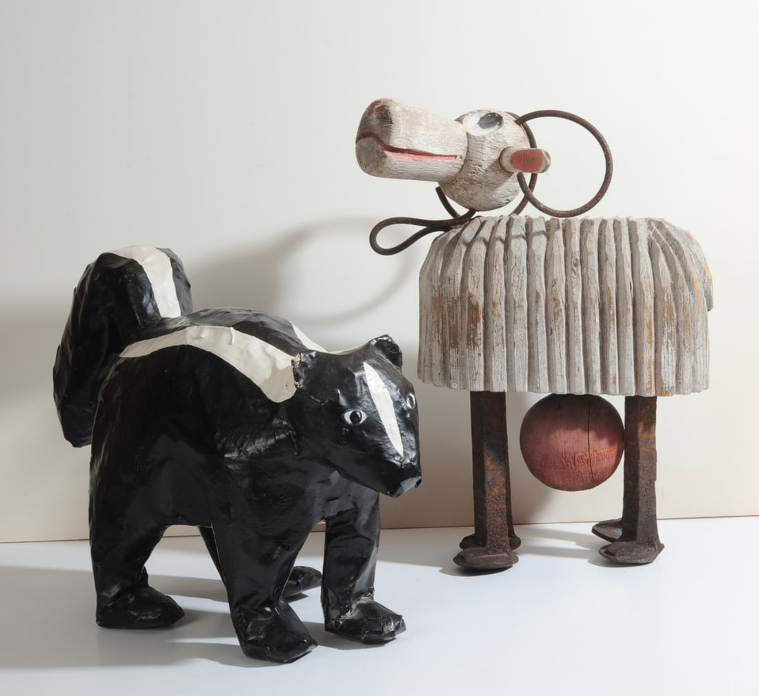 Two Handcrafted Folk Art Animal Figures: Papier Mache skunk signed “Kim Dickey” on the underside and dated 1984 (small tear to one ear), and a sheep constructed with a carved wooden head and ribbed body, painted details and four rail
