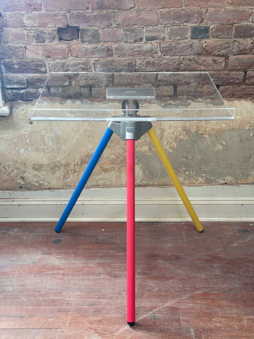 Marc Newson Tripod Book Stand: Marc Newson, Tripod Book Stand, 21st century. Acrylic book support on an aluminum tripod base, produced for Taschen. This particular colorway was originally released in conjunction with the limited-ed