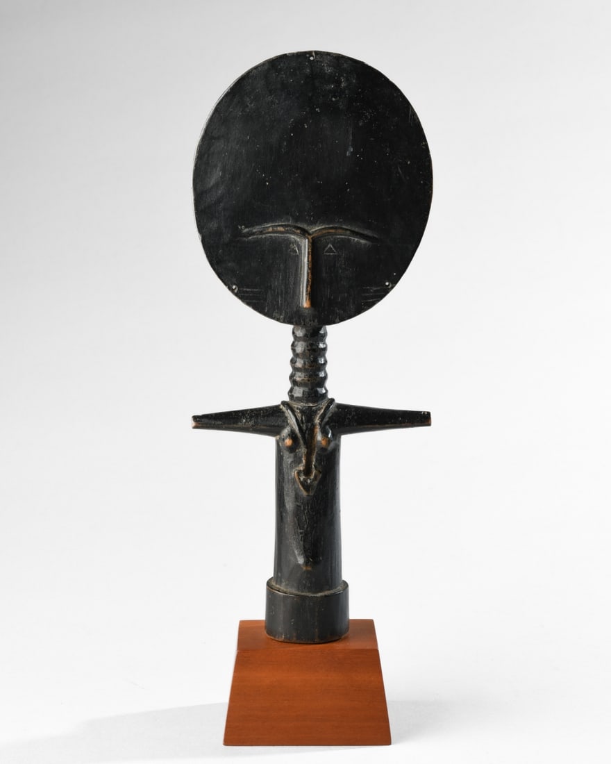 Ashanti Akuaba Doll, Ex Merton Simpson: Ashanti doll in black stained wood, the flat, elongated disc shaped head with nose and brows in relief, and incised triangular eyes and cheek striations. Back of the head with incised geometric