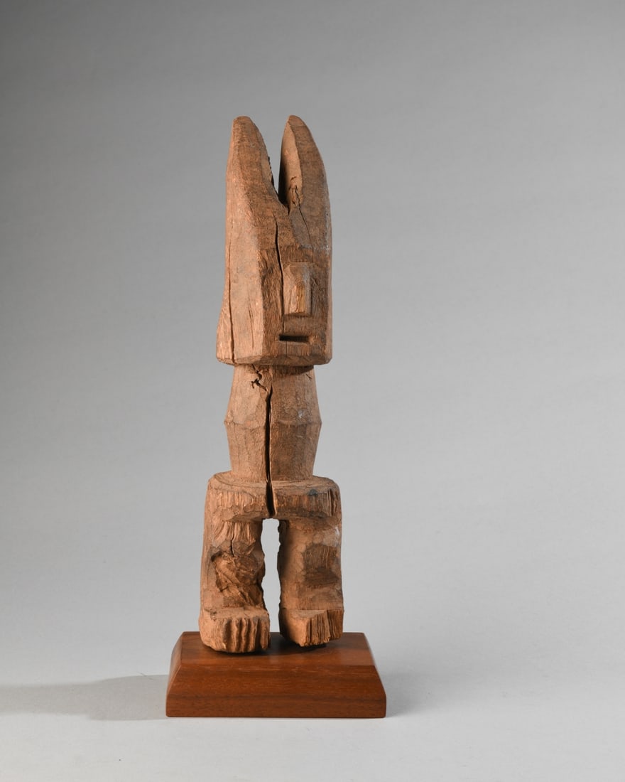 West African Shrine Figure, Lobi?: Blocky carved hardwood figure with long horns or ears, the flat, rectangular face with minimalist nose and mouth, no eyes, the columnar body with no arms, thick legs slightly bent at the knees.