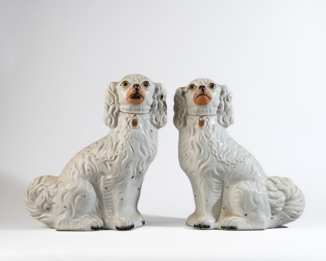 Pair of Staffordshire Pottery Spaniels: Both with extensive overall crazing, scattered firing flaws and glaze imperfections, minor losses. General surface wear and spotting consistent with age. Height approx. 12 3/4".Our primary