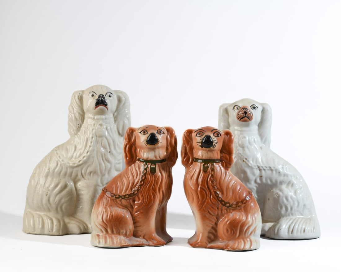 Four Staffordshire Pottery Spaniel Figures: Comprising one pair and one near-pair of seated spaniels, including two in cream glaze with molded fur and minimal polychrome decoration, and a pair decorated in copper tones with painted collars and
