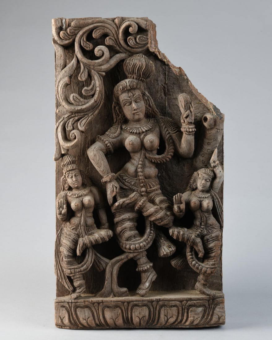 Indian Carved Wood Figural Panel Fragment: Carved hardwood fragment with a central female figure flanked by attendants and foliate decoration. Likely architectural. India, late 19th to early 20th century. ADD DIMESNIONS Our primary recommendat