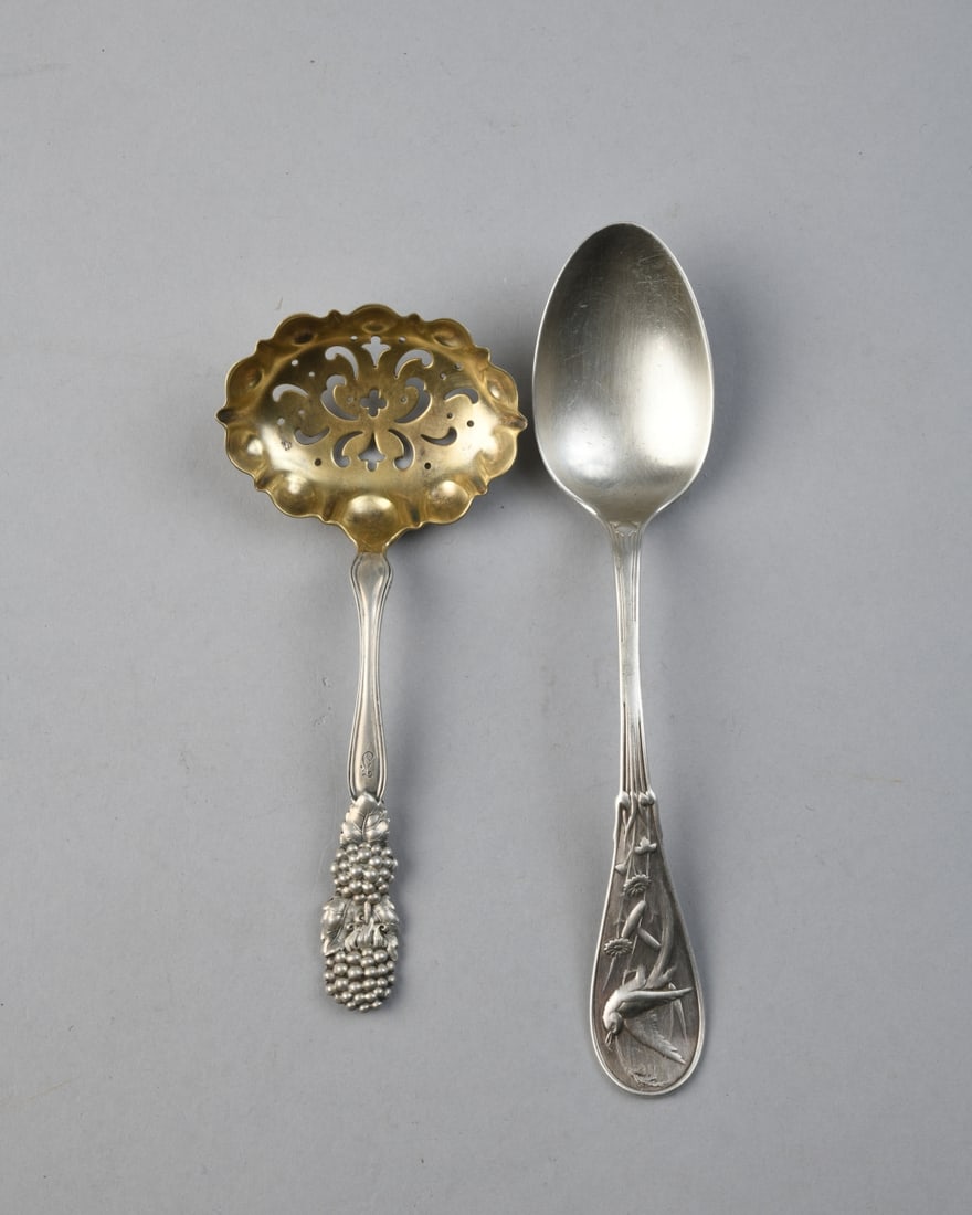 Two Tiffany & Co. Sterling Silver Spoons: Both marked, one monogrammed and with fitted Tiffany cloth bag (damage and wear to bag), one mark faded nearly completely off, Longest: approx. 7". Total weight: approx. 2.76 ozt.Our primary