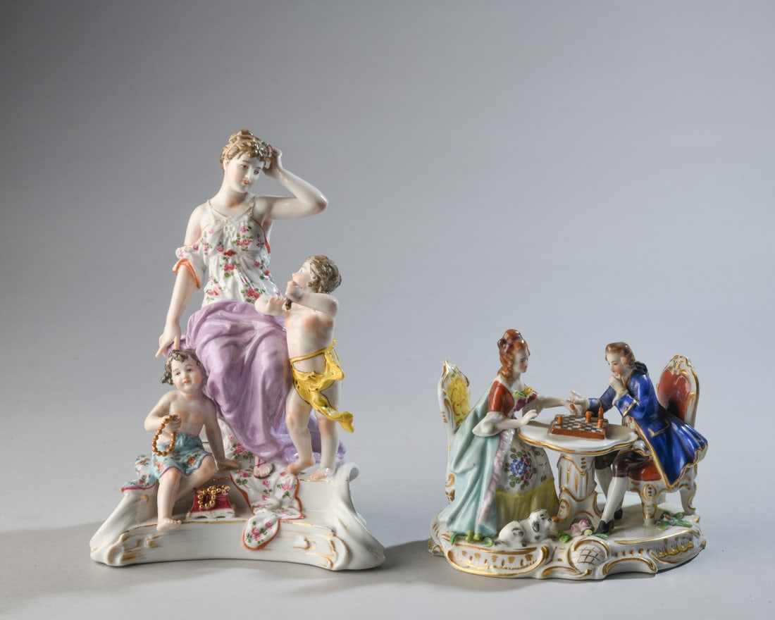 Pair of Continental Porcelain Figural Groups: Both circa early 20th century, the larger depicting a young woman with putti, with pseudo-Meissen crossed swords mark, the other depicting a man and woman playing chess, with Chelsea-style gilt anchor