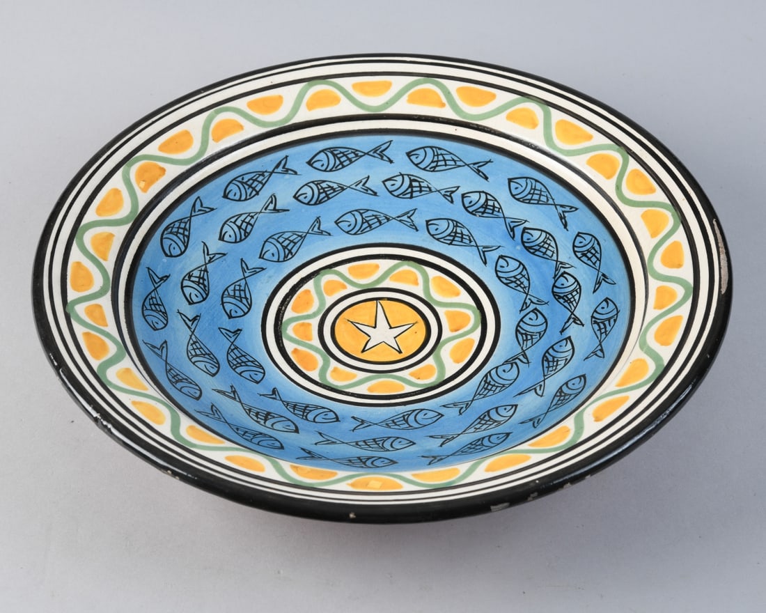 Italian Majolica Fish Charger: Circular earthenware charger with polychrome tin-glazed decoration, likely mid to late 20th century, painted with concentric bands of stylized fish on a blue ground, enclosing a central star medallion