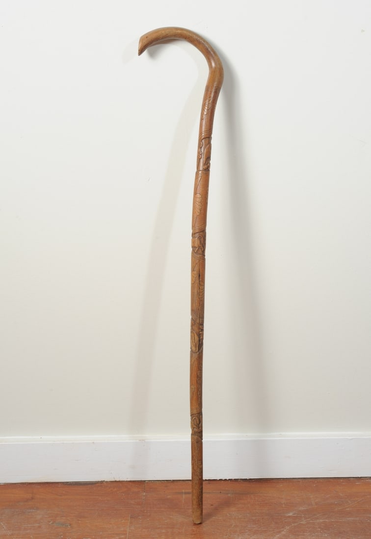 Mexican Carved Folk Art Walking Cane: Carved in relief with matador figures and bulls, and a Mexican eagle devouring a serpent. Vintage or antique. Crooked handle; surface wear and age cracks consistent with use. Length approx. 36". Our p