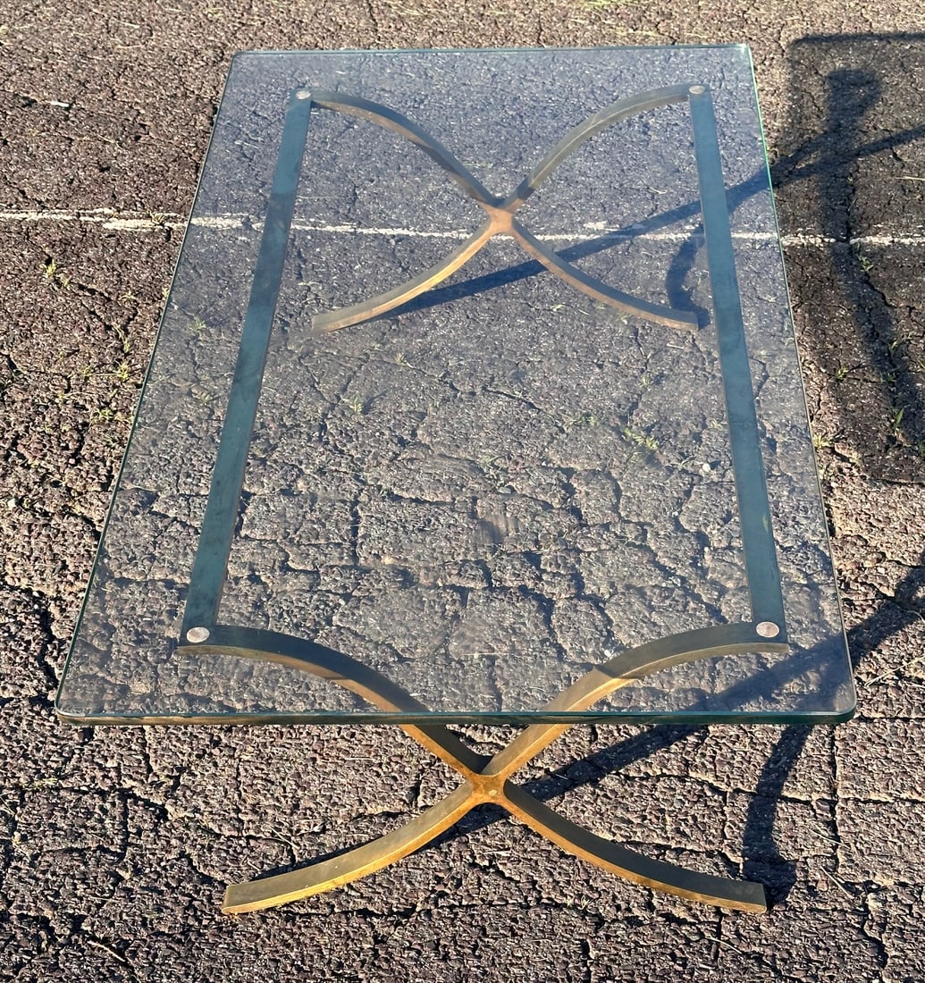 Late 20th C. Glass Coffee Table: Rectangular glass top with rounded corners, set on a brass-tone metal base with curved X-form supports and rectangular stretcher frame; late 20th century. Approx. 14 1/2" x 52" x 27 3/4". Our primary