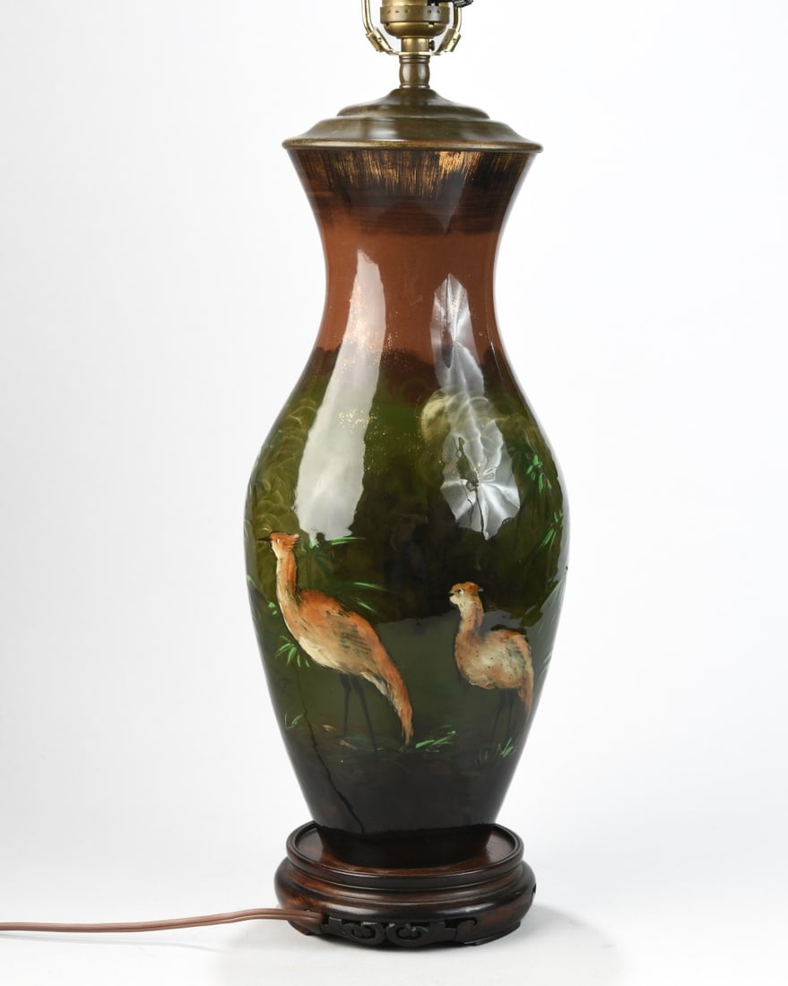 Rookwood Pottery Vase Converted to Lamp: Decorated with a marsh landscape featuring wading birds. Impressed factory mark to underside. Drilled and mounted as a table lamp. Height to finial approx. 27 3/8". Our primary recommendation is to ar