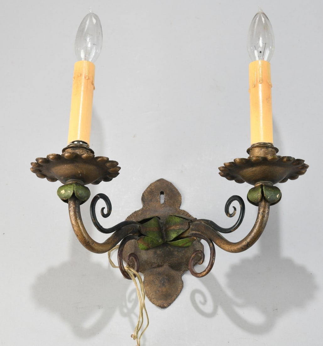 Two Light Electric Wall Sconce: Cast and wrought metal wall sconce with scrolling arms and foliate elements, retaining a gilt and polychrome (green) finish, fitted with two faux candle sockets and modern wiring, likely mid 20th cent