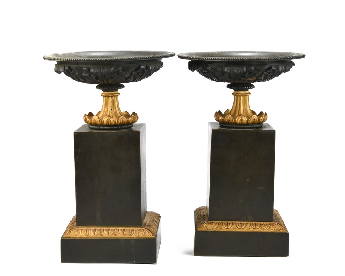 Pair of Patinated and Gilt Metal Tazzas: Each with a shallow circular dish with beaded rim and cast foliate underside, drilled holes to wells, on a fluted standard with acanthus collar, raised on a square plinth base, probably early 20th