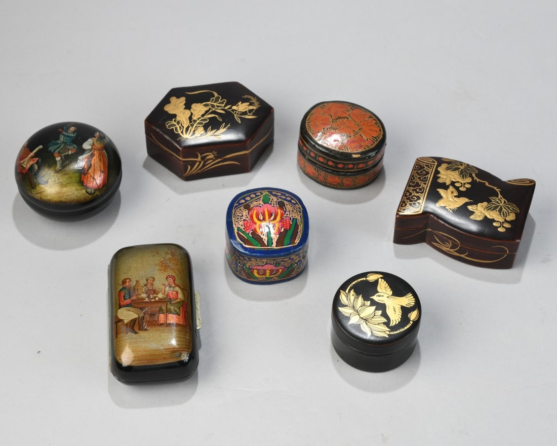Group of Seven Small Lacquered Boxes: Various shapes and decorations including gilt chinoiserie and figural scenes; mixed manufacture, one marked “Made in India,” 20th century; with surface wear, scratches, and minor losses.