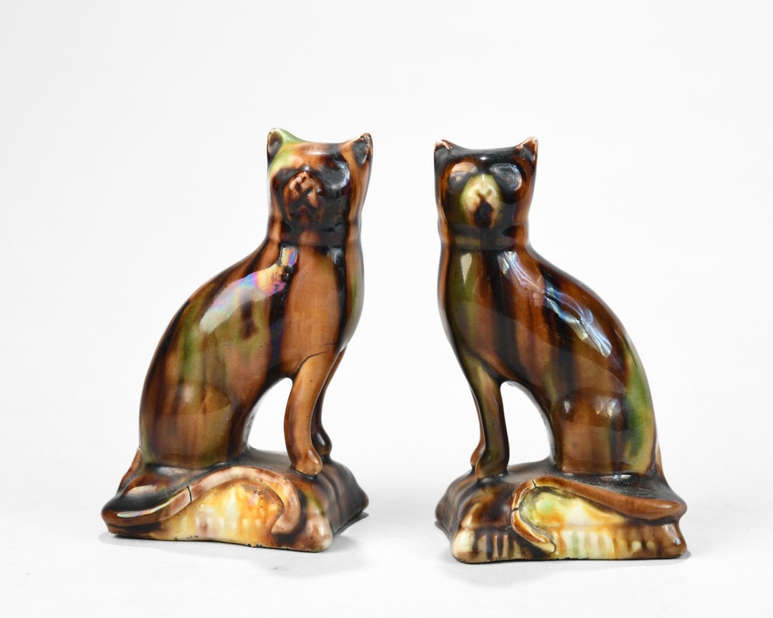 Pair of Glazed Ceramic Cat Figurines: Mid 20th century, modeled as seated cats on shaped bases with mottled brown, amber, and green drip glaze; unmarked; glaze crazing and minor firing imperfections, one with minor chip to ear. 4" x 2 1/8