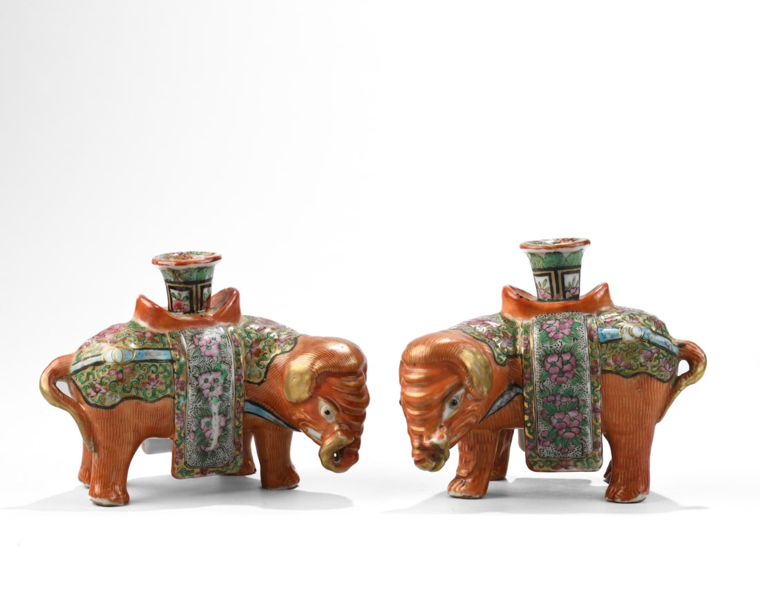 Pr. of Chinese Export Elephant Form Candle Holders: 20th century, modeled as caparisoned elephants with upright candle nozzles, decorated in famille rose palette with gilt accents; unmarked; one with small chip to foot, otherwise minor wear and some mi