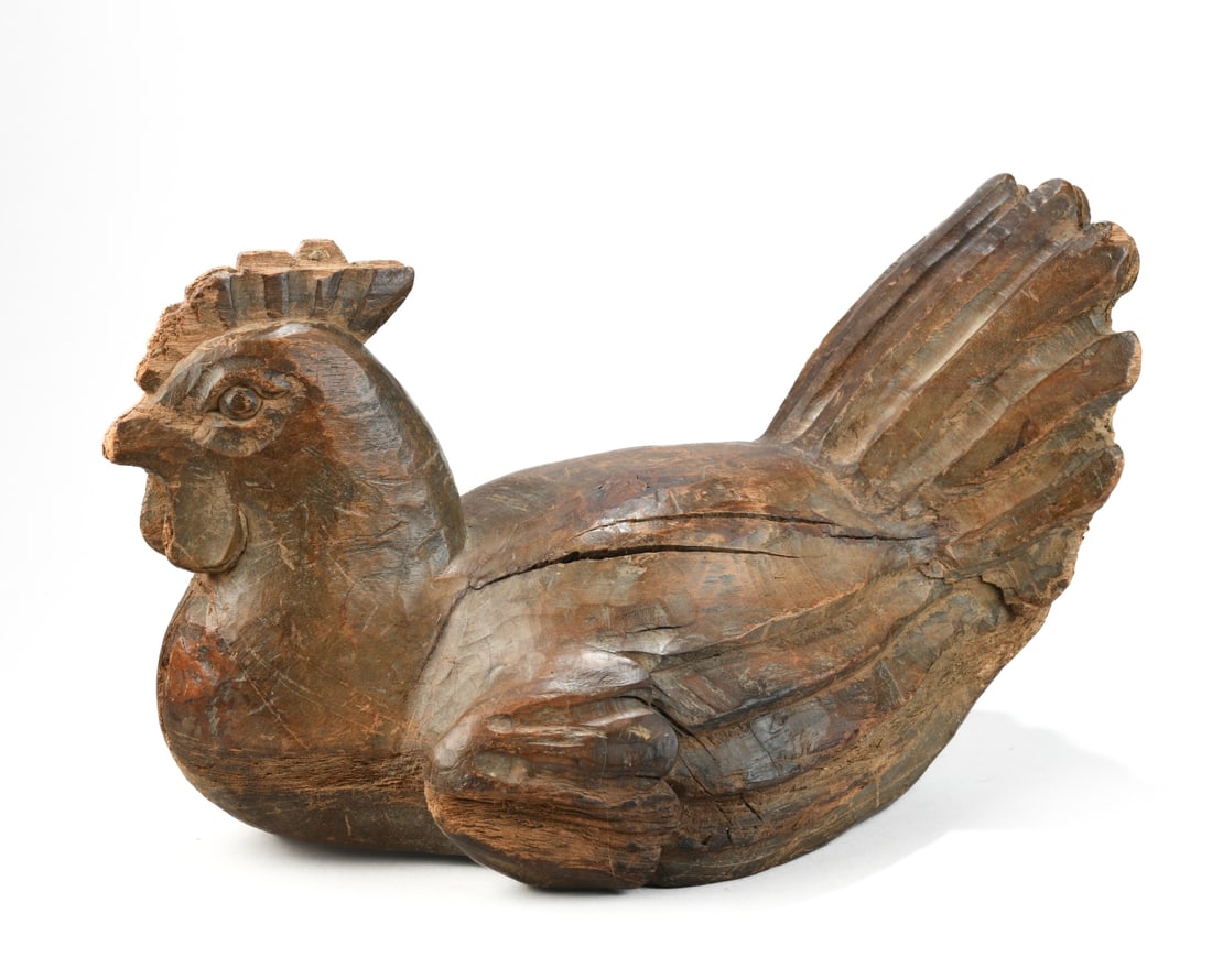 Folk Carved Wooden Hen: Probably 20th century, carved figure with feather and comb detail, surface darkened from age and handling, flat base allowing it to sit upright, age cracks and separations throughout, some losses and 