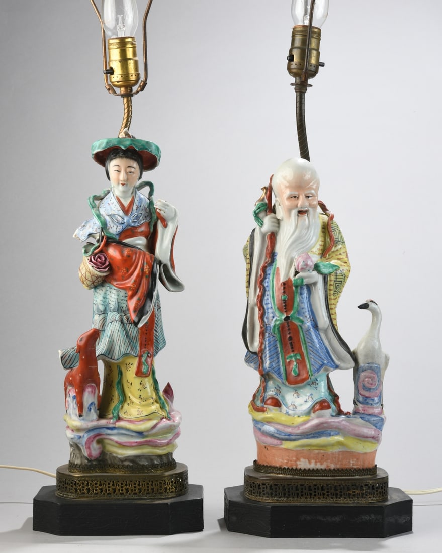 Two Chinese Export Figural Lamps: Pair of Chinese export polychrome porcelain figural lamps modeled as an immortal with crane and a female figure with parasol, on pierced metal bases, electrified; both show damage, female with missing