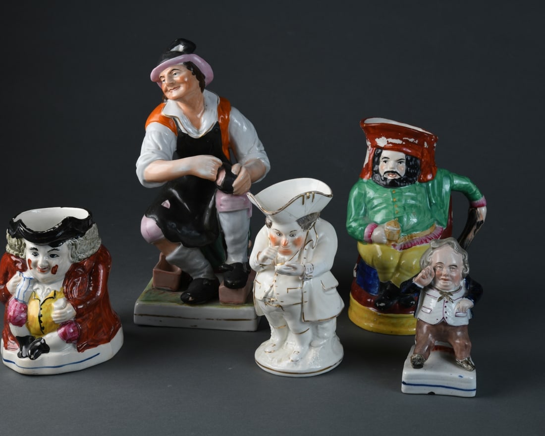 Five Piece Staffordshire Grouping: Five English ceramic figural pieces, including three character jugs and two seated figures, late 19th / early 20th century. Comprising a polychrome Toby-type jug of a seated drinker in a red hat; a wh