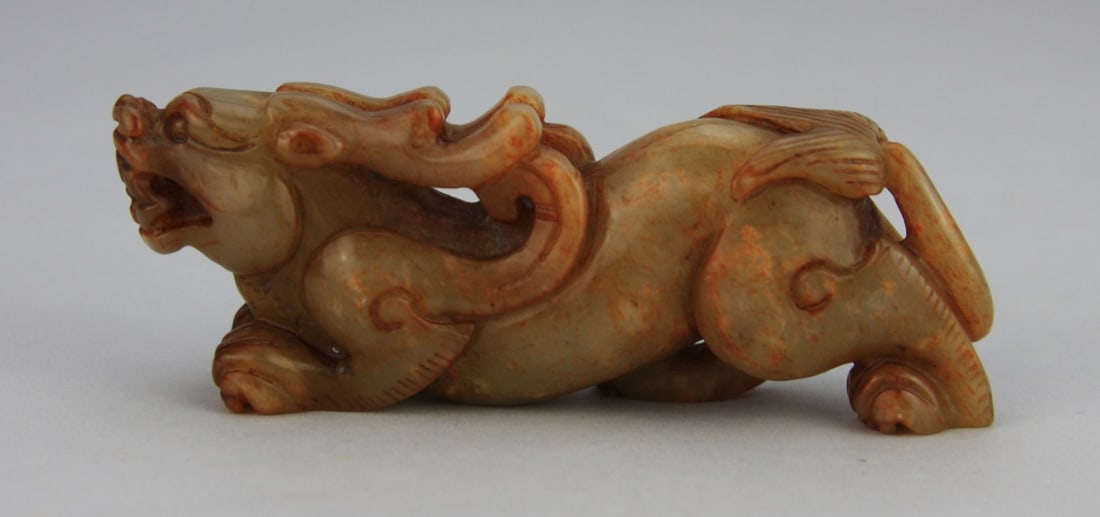 Chinese Carved Jade Recumbent Dragon: Chinese carved celadon and russet jade figure of a recumbent dragon. 4 1/2' long. Light wear. and calcification. Our primary recommendation is to arrange shipping yourself using Blue Ridge Pack & Ship