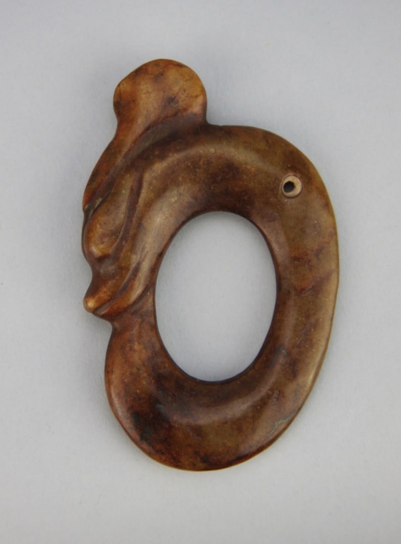 Chinese Carved Russet Jade Pendant of a Dragon: Chinese carved russet jade pendant of a dragon figure eating its tail. Light surface wear and oxidation. 3 1/2" high. Our primary recommendation is to arrange shipping yourself using Blue Ridge Pack &