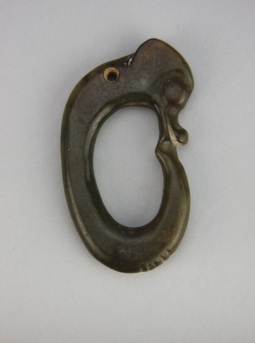 Chinese Carved Green Jade Hooked Dragon Pendant: Chinese carved green jade hooked dragon pendant. Light surface wear. 2 3/4" high. Our primary recommendation is to arrange shipping yourself using Blue Ridge Pack & Ship. Most bidders find this is the