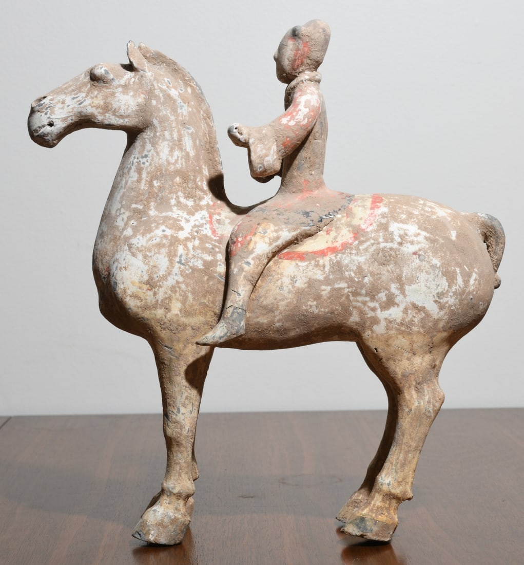 Antique Chinese Painted Pottery Equestrian Figure: Han style, unglazed buff earthenware horse and rider, the standing horse with crenellated mane, pricked ears, and bound tail with rider seated astride. Retaining substantial traces of white slip and r