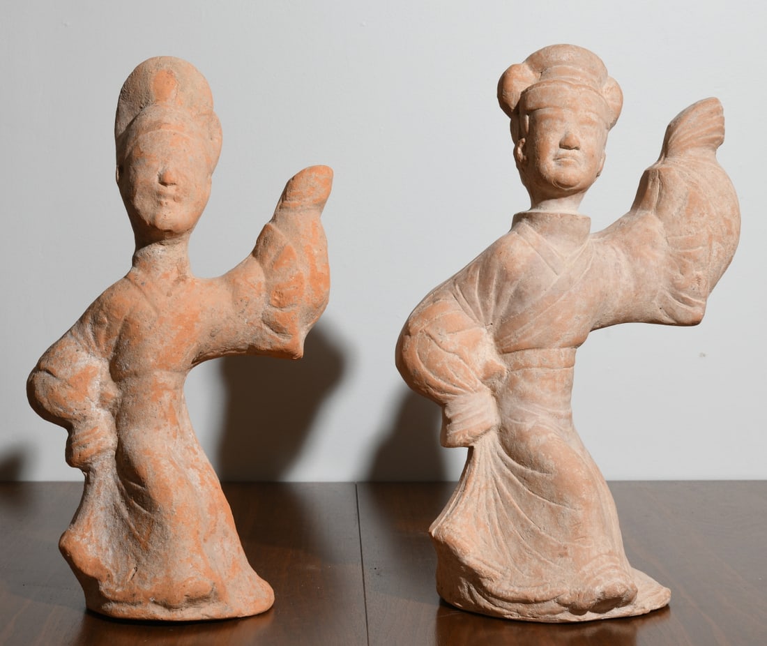 2 Chinese Pottery Han Style Dancers: Two unglazed buff earthenware figures of standing female dancers, each modeled with elaborate coiffure and long flowing robes, raised in the "long sleeve dance" gesture, on integral hand-formed bases,