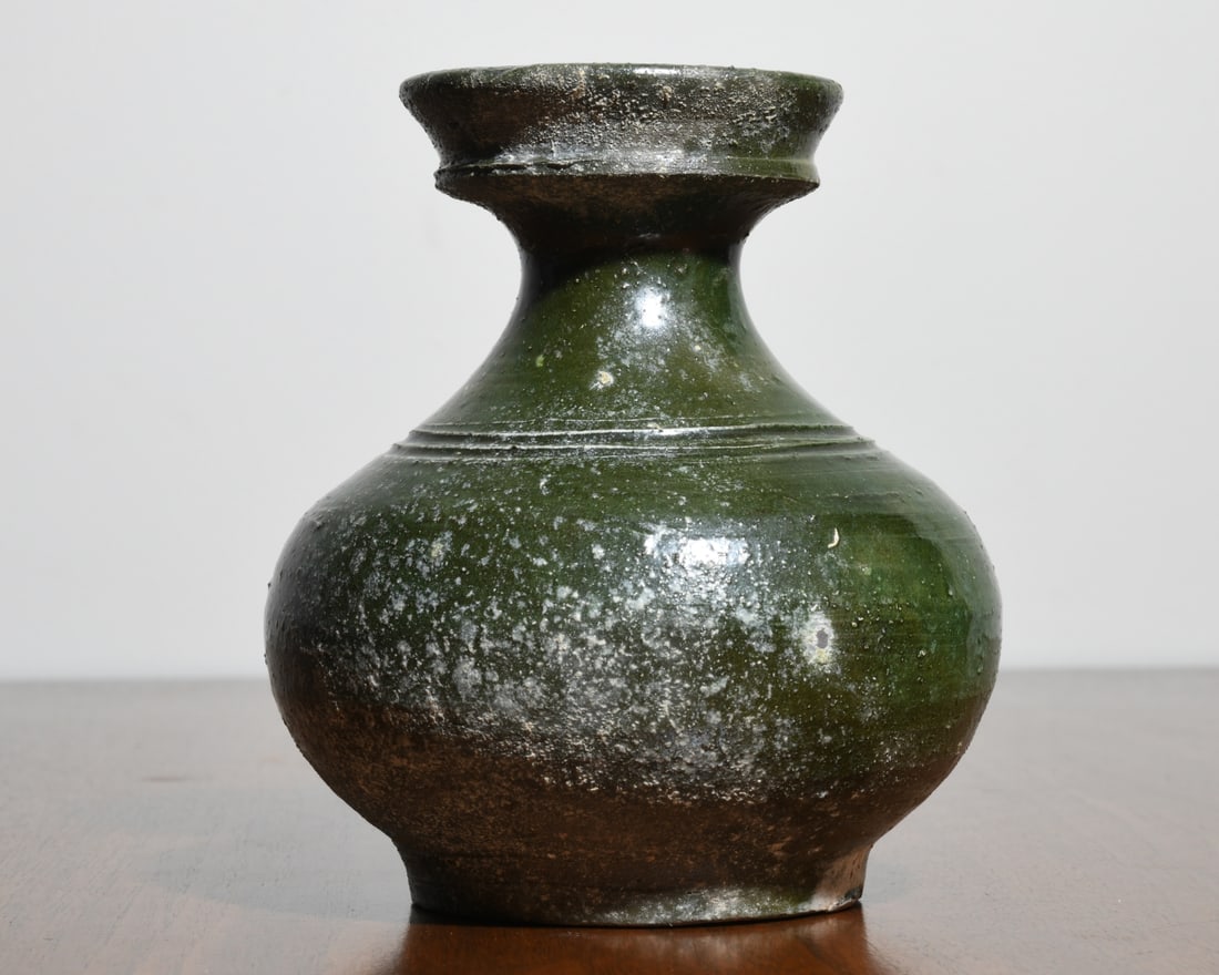 Chinese Green Glaze Pottery Vase: Baluster form vase with flared rim and narrow neck, covered in a mottled green glaze with estensive surface accretions and weathering, archaistic Han style (probably later), unglazed base showing conc