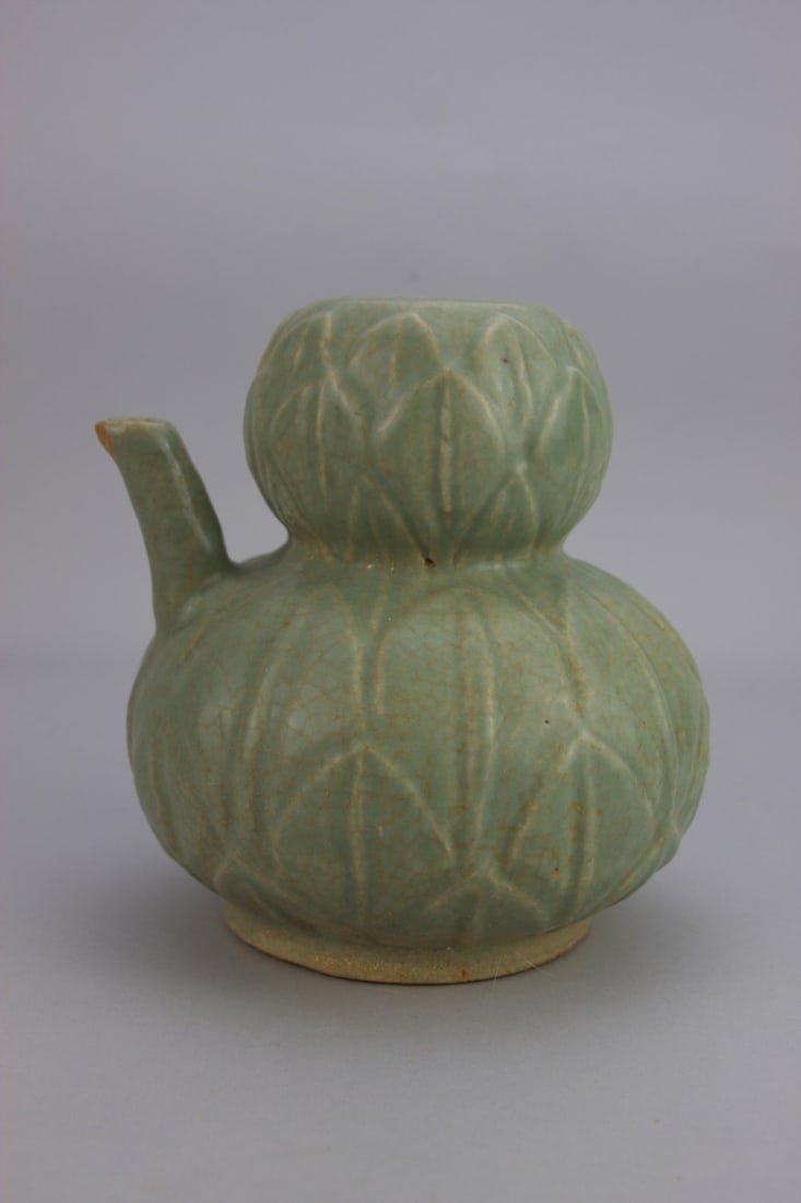 Chinese Celadon Ewer or Jug: Chinese celadon glazed mystery ewer or jug. Incised leaf design. Small chip on spout. 7' high. Our primary recommendation is to arrange shipping yourself using Blue Ridge Pack & Ship. Most bidders fin