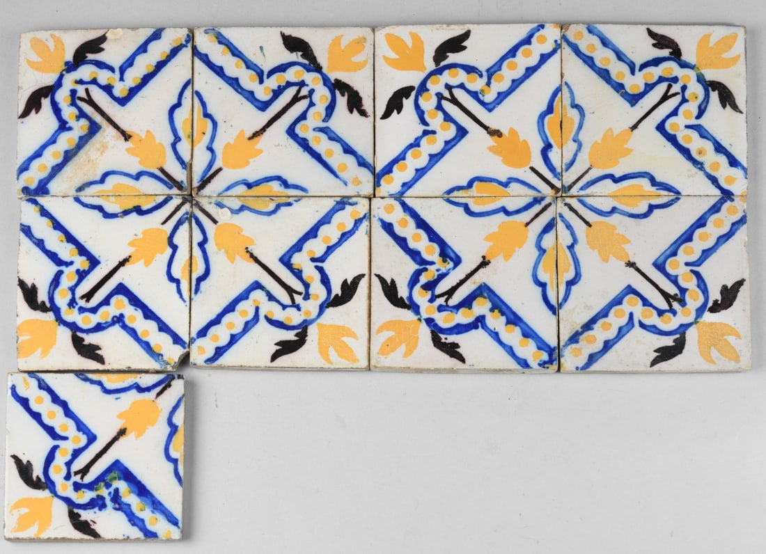 Nine Iberian Style Polychrome Tiles: Likely Spanish or Spanish Colonial revival, hand-painted earthenware with a repeating foliate and geometric motif in blue, yellow, and black, probably 20th century. Condition varied with minor chips, 