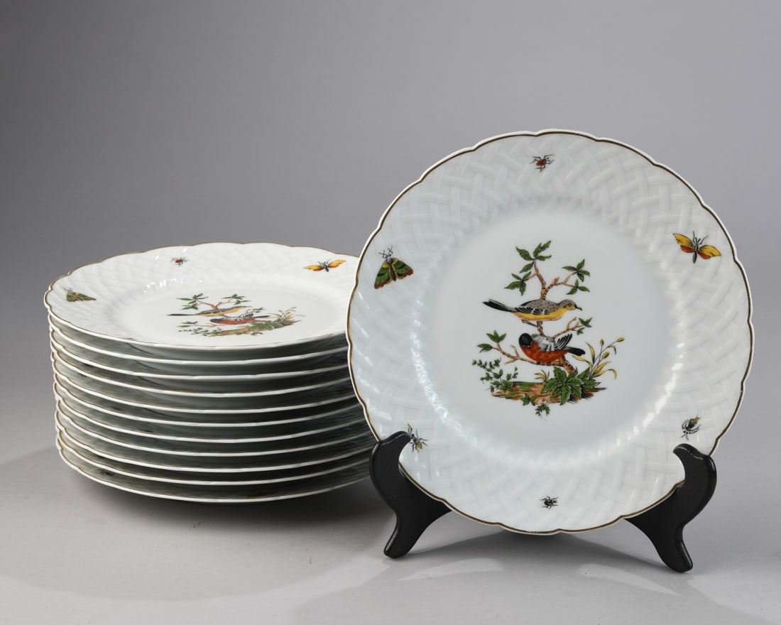 Twelve Limoges "Virginie" Plates: Each with a molded basketweave border and scalloped gilt rim, decorated with polychrome birds perched on branches with scattered insects to the border; marked to verso, early 20th century. Light surfa