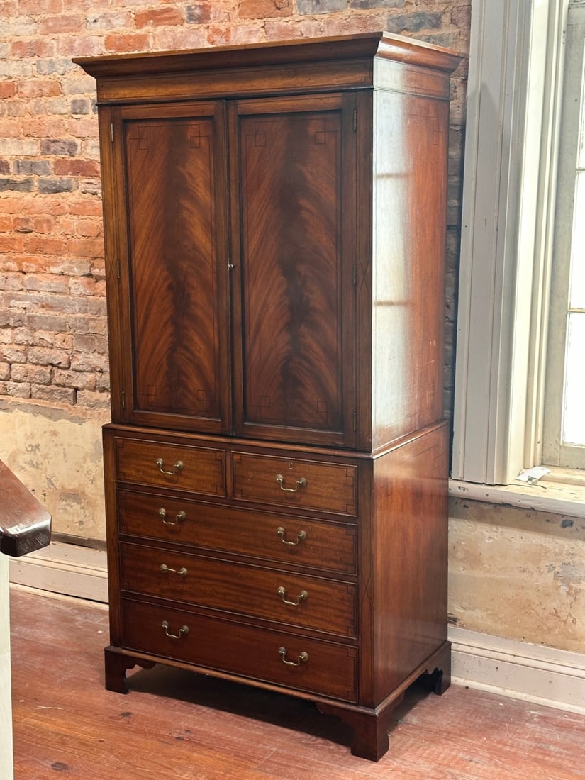 George III Style Mahogany Linen Press: 20th century, molded cornice over paneled doors opening to interior storage, lower section with two short drawers over three long drawers, bracket feet, string inlay, some wear and scuffs. Dimensions