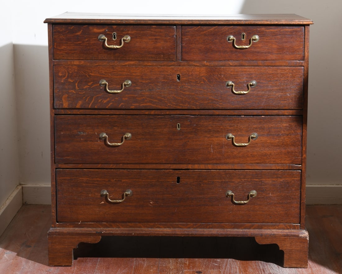 19th C. English Oak Bachelor's Chest: Molded edge top over two short dovetailed drawers with brass pulls over three long drawers, on bracket feet. Some minor damage and losses. Dimensions approx. 35" H x 36 3/4" W x 20 1/4" D. Our