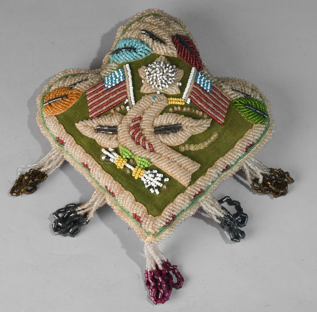 Late 19th/Early 20th C. Iroquois Beaded Pillow: Soft cloth form with dense beadwork, eagle and flag motif, tassel fringe, red fabric backing, some bead loss and loose threads. Dimensions approx. 10" x 10" x 2". Our primary recommendation is to