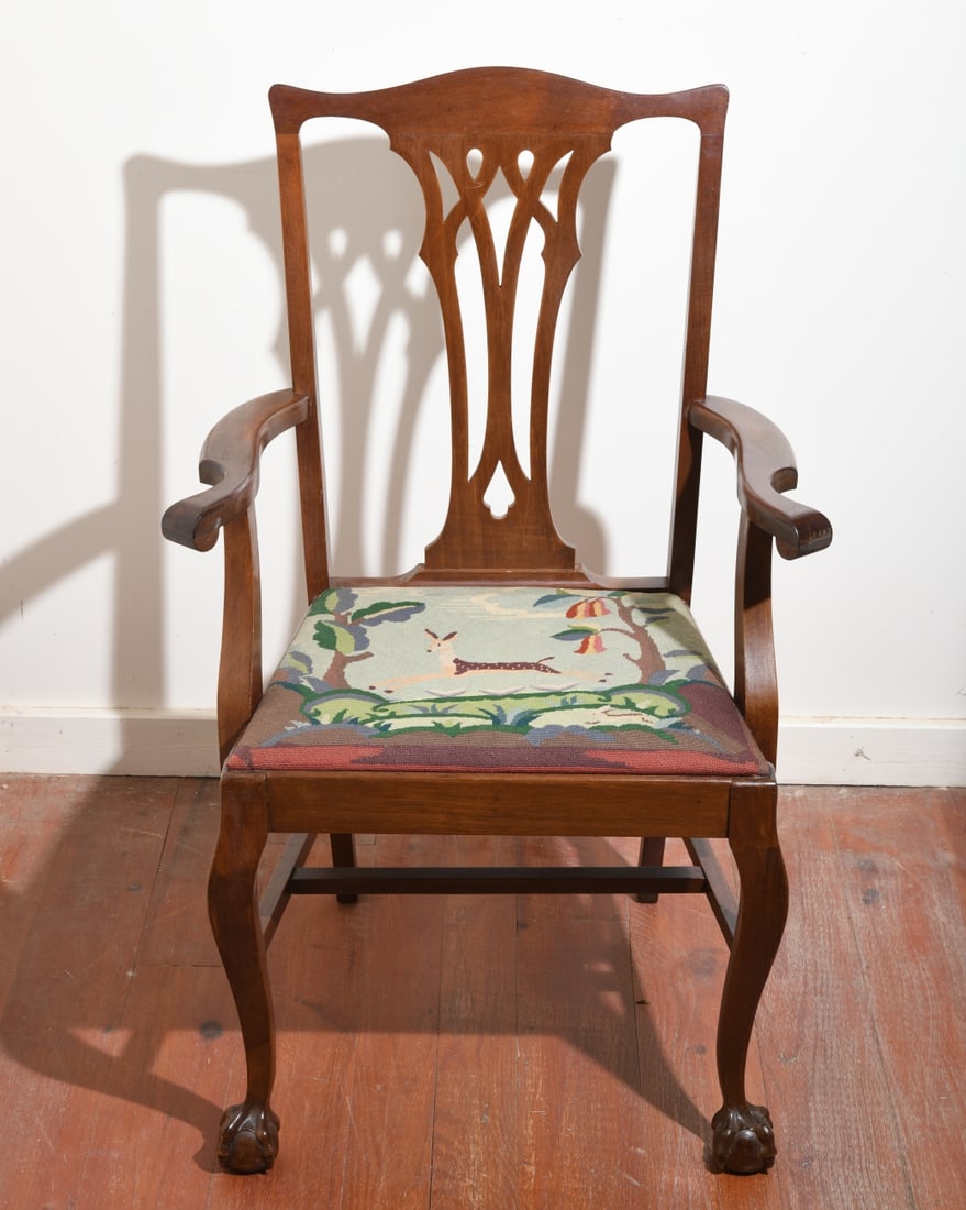 Reproduction Chippendale Style Armchair: With needlepoint slip seat bearing forest scene, shaped crest rail, pierced splat, curved arms, cabriole legs, ball and claw feet. Minor surface wear. Our primary recommendation is to arrange shipping