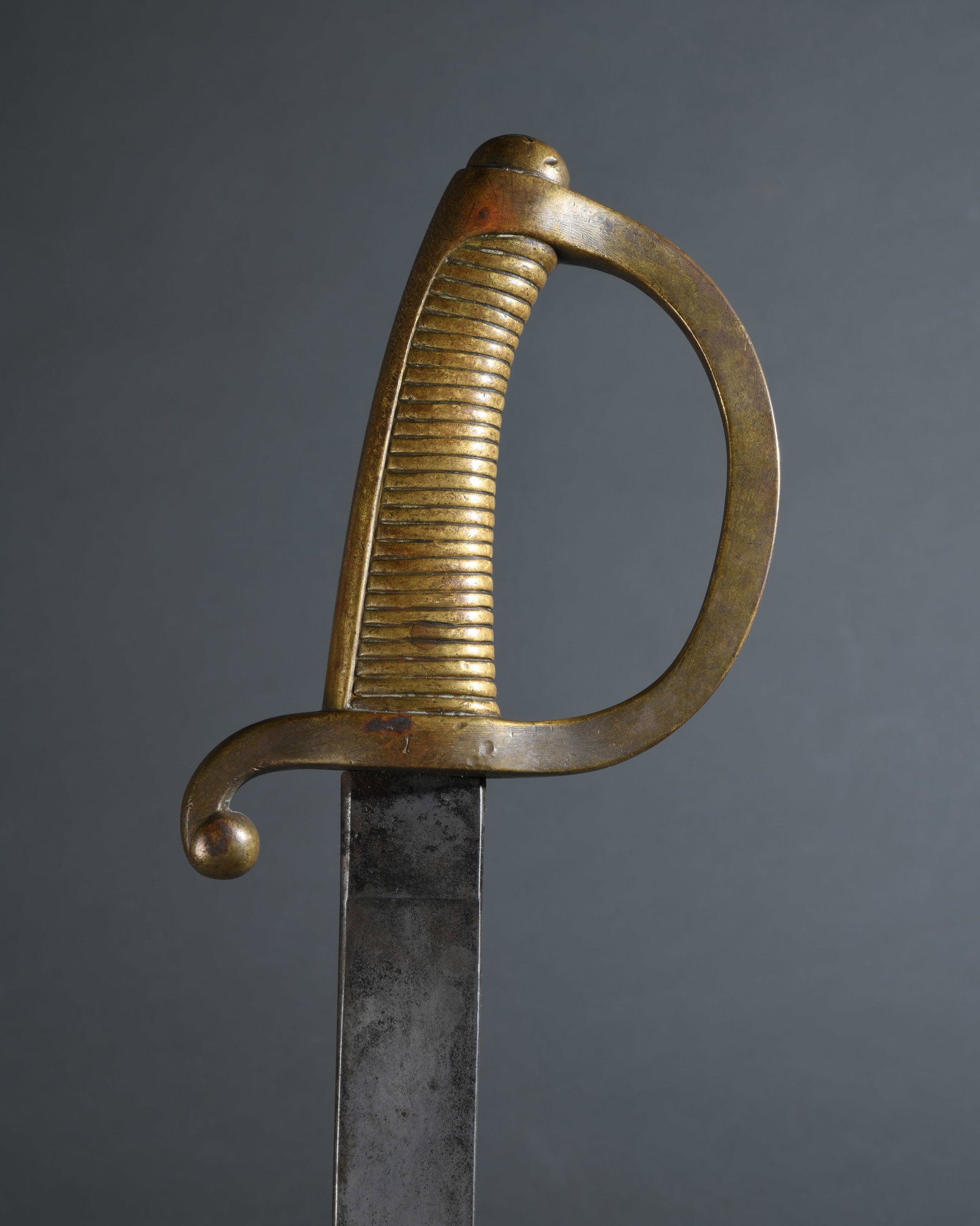 Spanish Model 1843 Short Sword: Infantry or artillery short sword dated 1856, broad single edged steel blade stamped “Fa D Toledo 1856” at the ricasso, cast brass hilt with ribbed grip, D-form knuckle bow, and scrolling quil