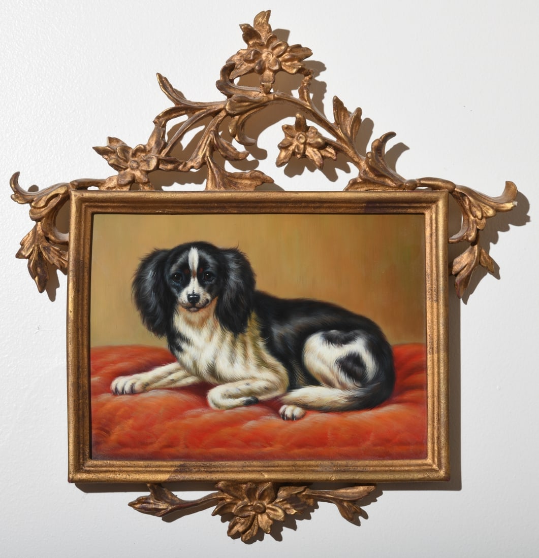 Chelsea House Dog Portrait in Gilt Frame: late 20th century, depicting a black and white spaniel-type dog reclining on a red cushion, housed in an ornate gilt floral openwork frame. Retains Chelsea House, Gastonia, North Carolina label verso,