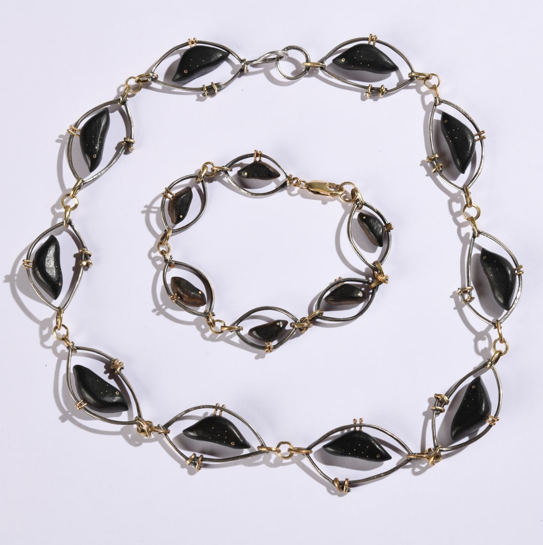 Carolyn Morris Bach Necklace and Bracelet: Matching necklace and bracelet featuring black birds, Sterling and 18k, bracelet clasp marked 585. Necklace total L: approx. 18". Bracelet total L: approx. 7". Our primary recommendation is to
