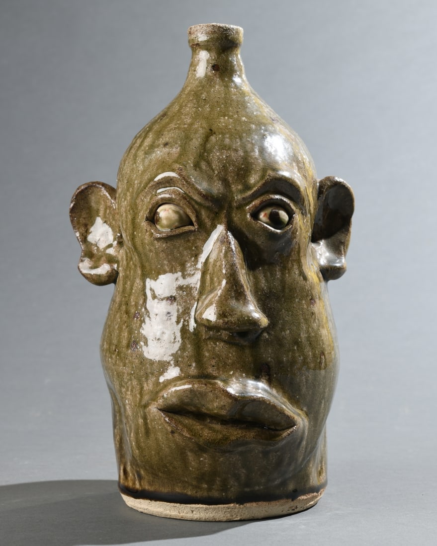 David Meaders Face Jug: Glazed stoneware with applied ears and painted eyes, signed “David Meaders” to shoulder, late 20th century. No visible chips, cracks or repairs. H: approx. 12", approx. 6 1/2" from nose to