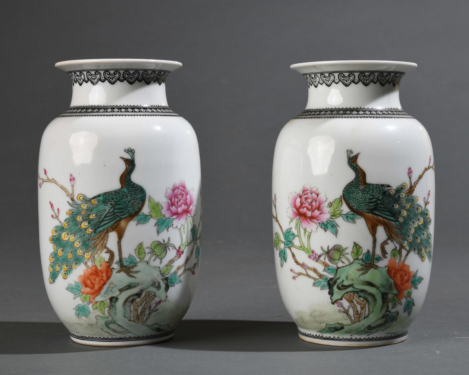 Pair of Chinese Porcelain Vases: Rouleau form with flared rims, decorated in famille rose enamels with peacock and flowering branch motifs, verso with calligraphic inscriptions and red seals beneath blue patterned collar borders. Bea