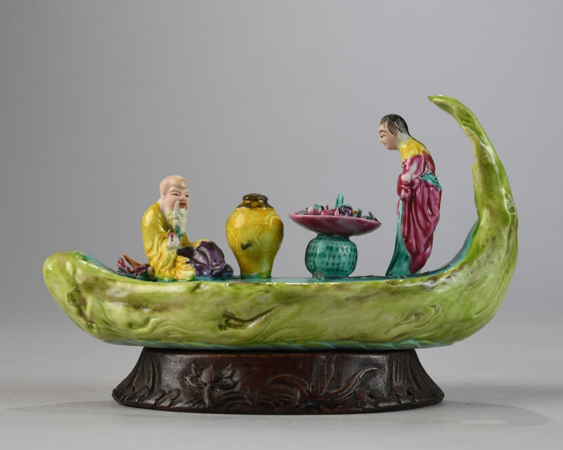Chinese Export Figural Grouping: Chinese export porcelain figural group in the form of a boat with seated male figure and standing attendant flanking a table of offerings, polychrome enamel decoration in famille verte palette, Canton