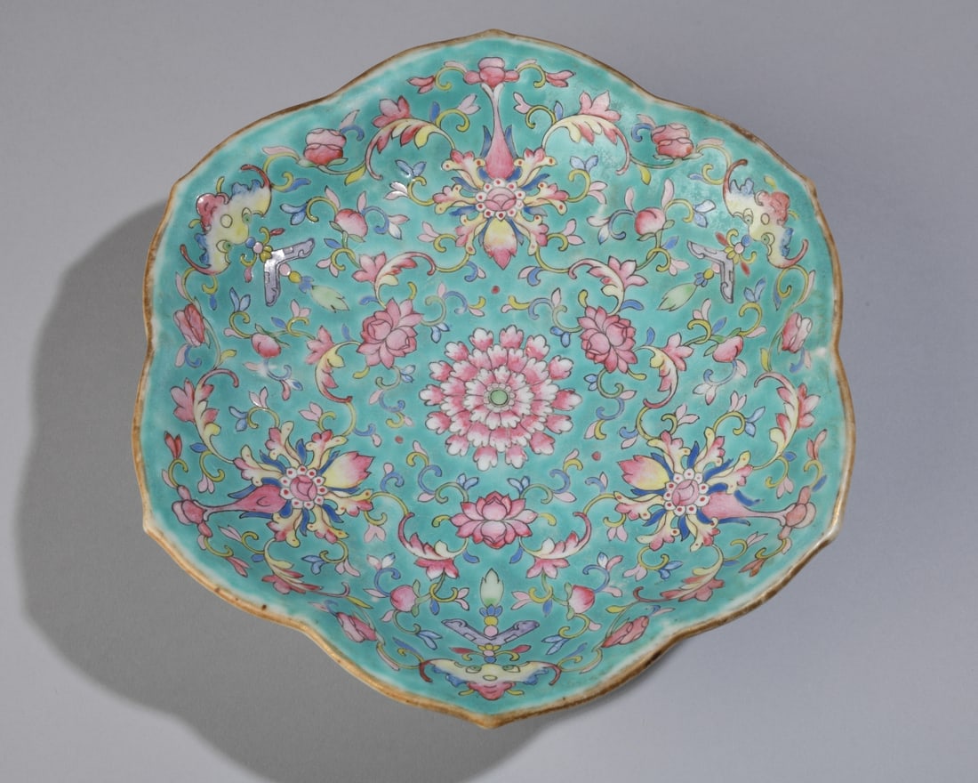 Chinese Famille Rose Pedestal Dish: A footed, lobed porcelain dish featuring a densely enameled pink lotus and bat motif against a vibrant turquoise interior, with sparse floral sprays on a white exterior. Late Qing to Republic Period.