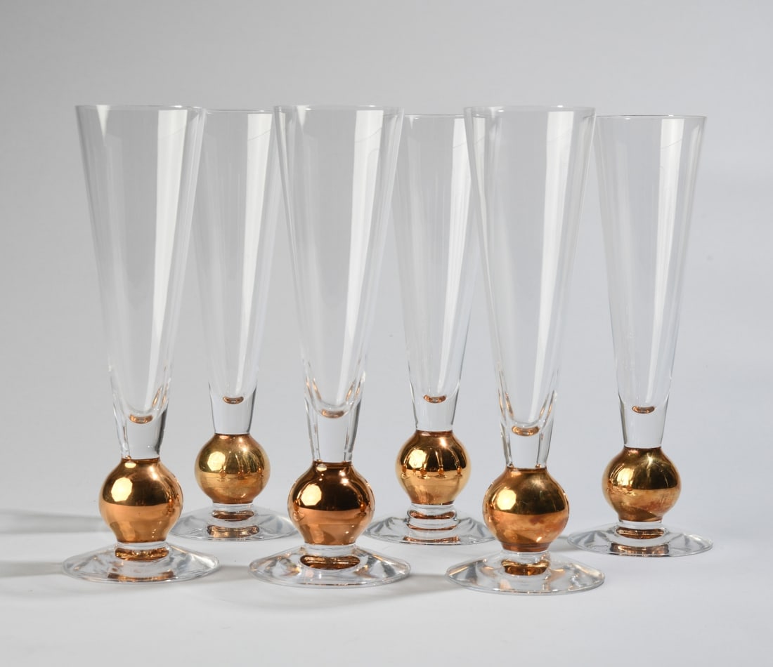 Six Orrefors Gunnar Cyren Nobel Champagne Flutes: Designed by Gunnar Cyren in 1991 for the 90th anniversary of the Nobel Prize. Made of crystal with hand painted details in 21k gold, five with maker's mark etched to underside. Dimensions approx. 8