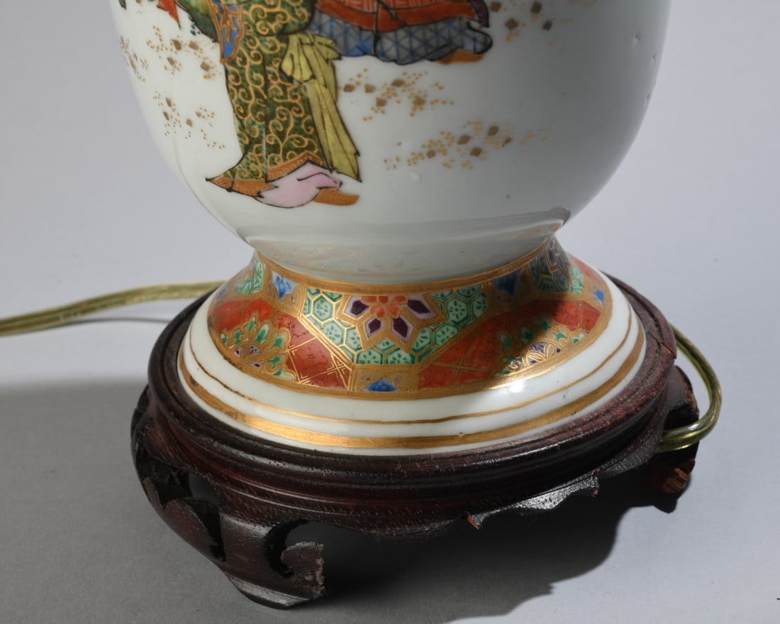 Japanese Porcelain Vase Table Lamp: Baluster form with twin molded handles, decorated in polychrome enamels and gilt, on wooden base, with brass-tone lamp hardware. Powers on. H: approx. 24 1/2" to top of finial. Dia: approx. 5 1/4".