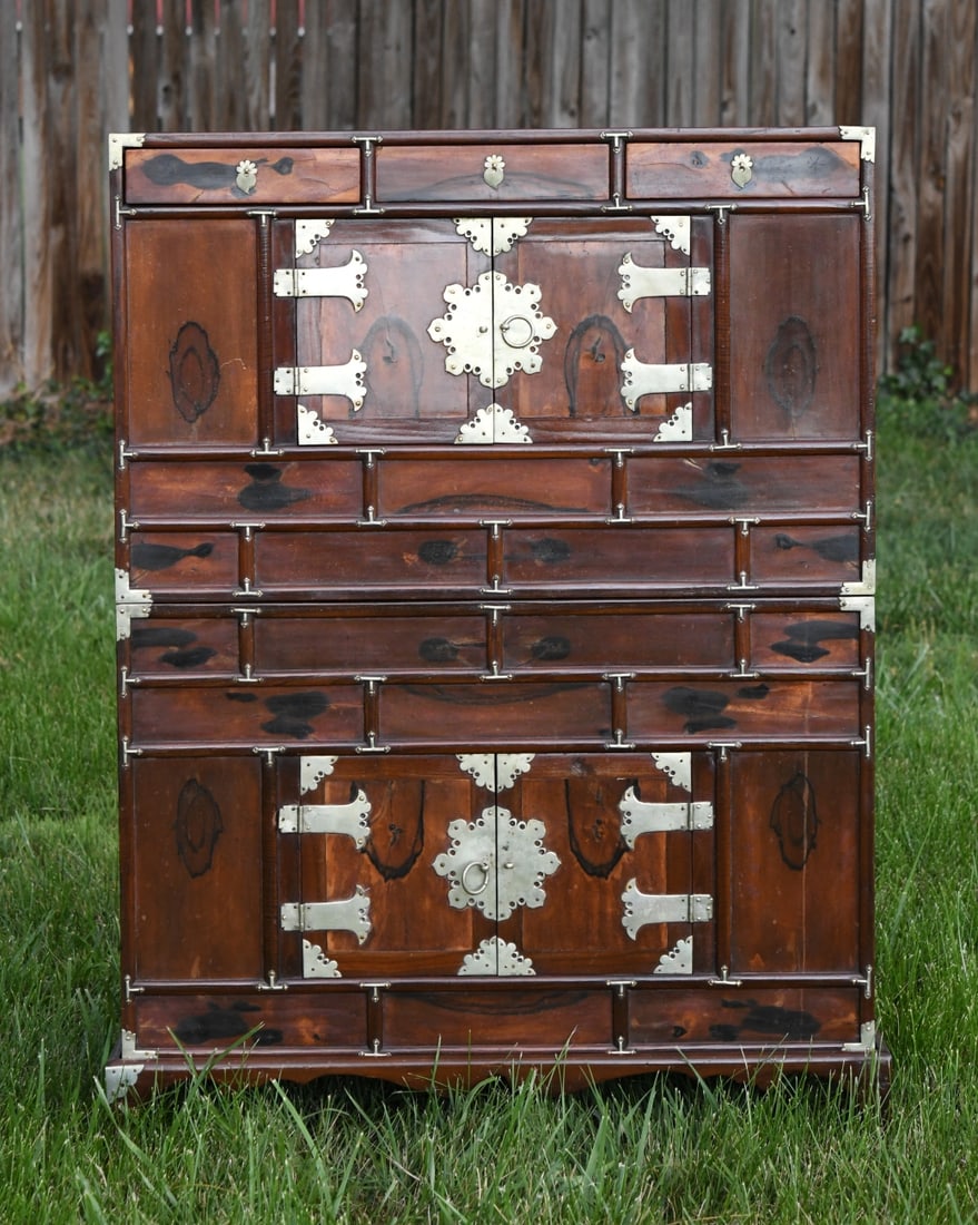 A Korean Persimmon Wood Chest-on-Chest: Constructed in two stacking sections on a low base, featuring highly figured persimmon wood front panels, the double doors and upper drawers open to traditional paper-lined interiors. Dimensions appro